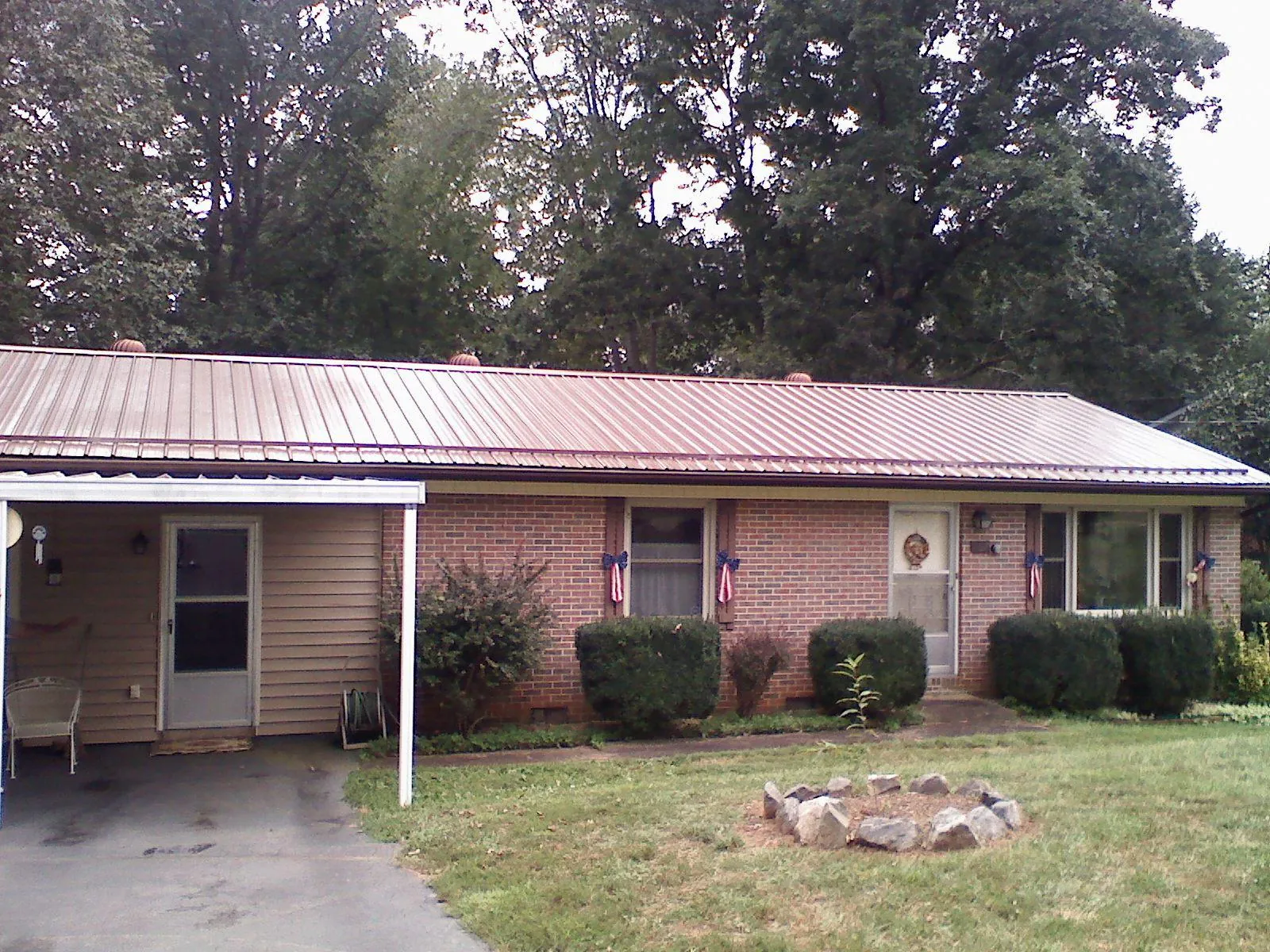 Bronze metal roof and carport on a brick ranch home — Roof Repair work by our crew in Springfield